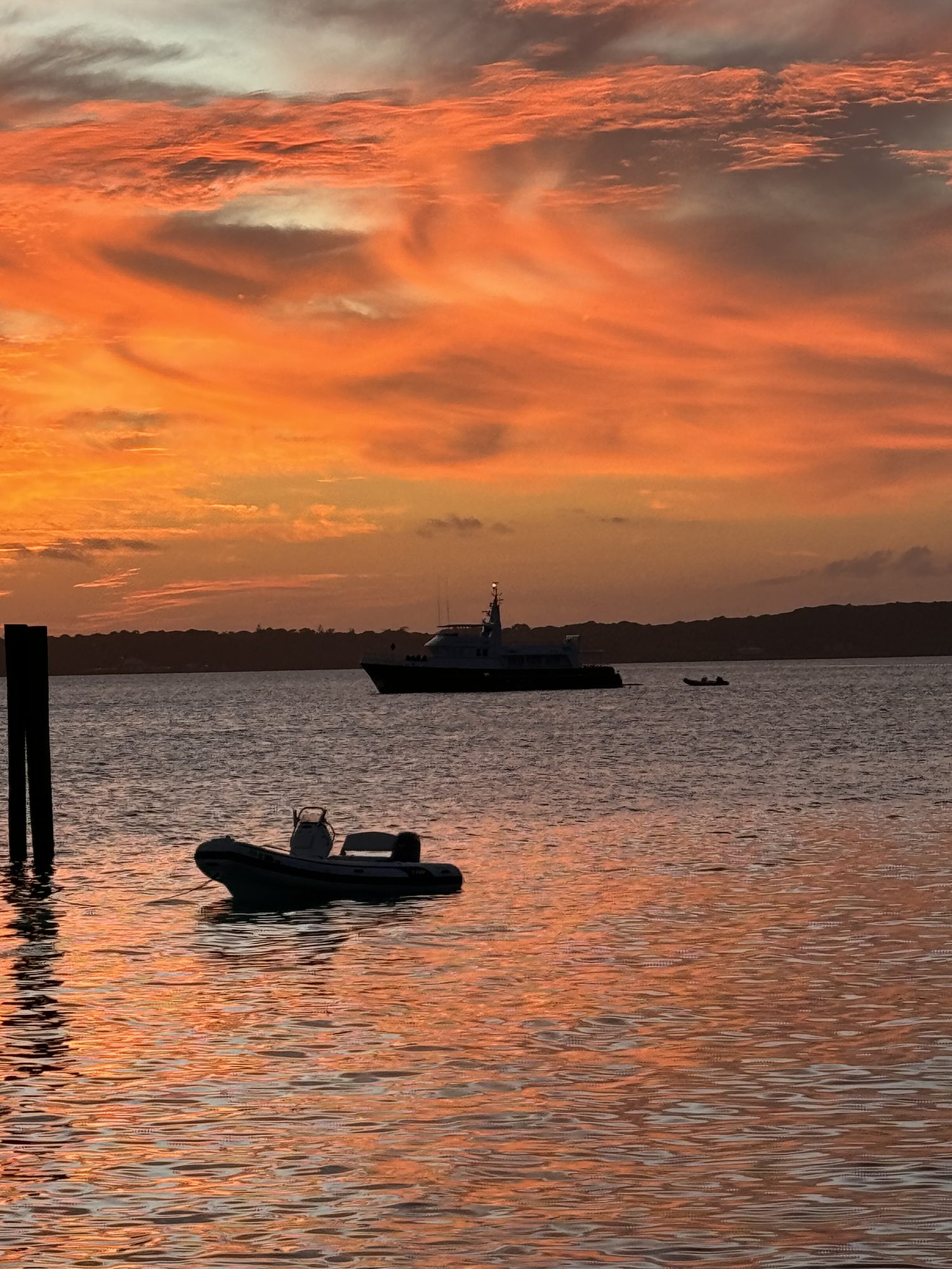 An orange sky over a quiet anchorage