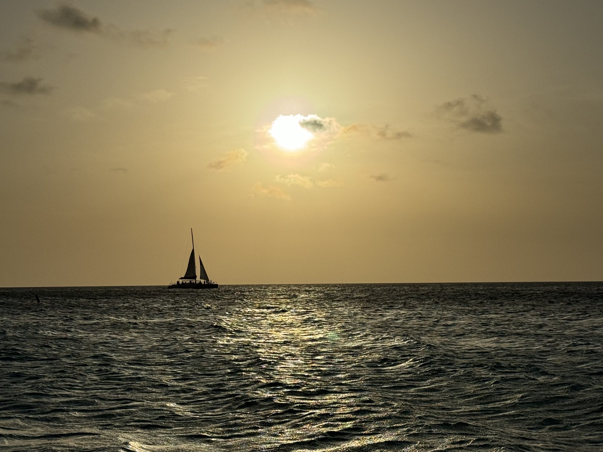 A sailboat against a low sun